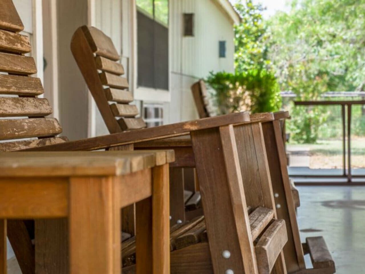 A wooden outdoor seating area with a table and chairs.