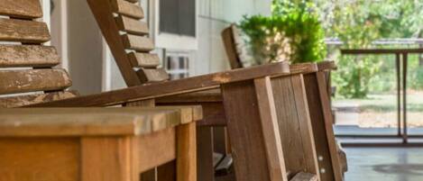 A wooden outdoor seating area with a table and chairs.