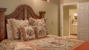 Un dormitorio con cabecera de madera, ropa de cama floral y un ventilador de techo.