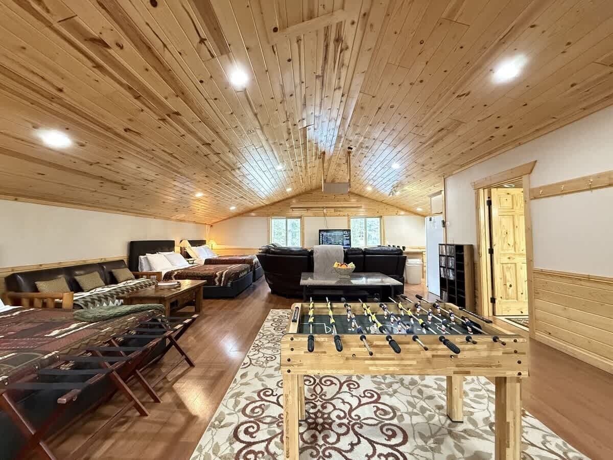A cozy living room with a foosball table, a sofa set, and a fireplace.