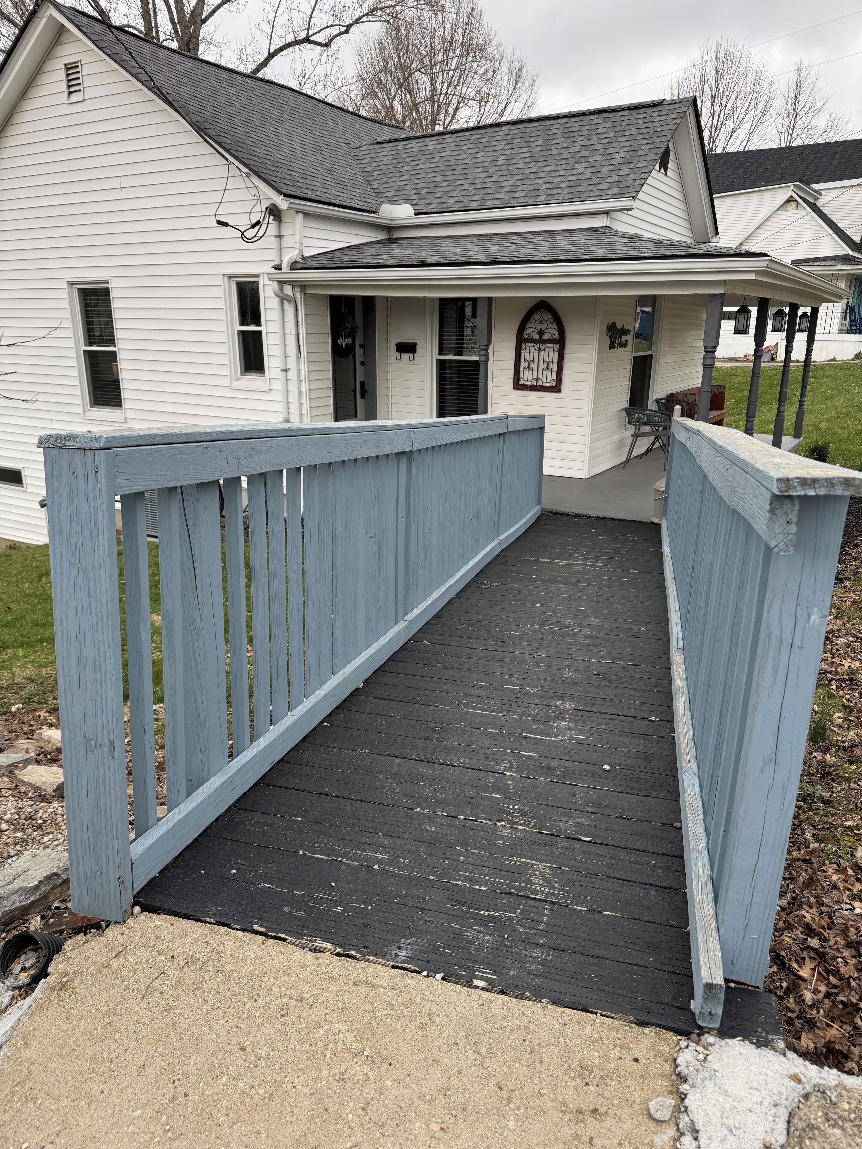 A house with a covered porch and a wooden deck leading to the entrance.