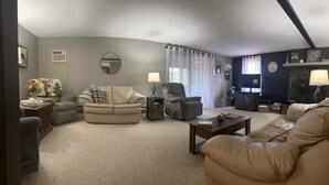A living room with a beige sofa, a recliner, a coffee table, and a fireplace. - Peaceful Mountain Cabin Near Lake Pactola – Perfect for Families or Couples (Rapid City)