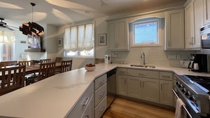 A modern kitchen with white cabinets, a large island, and a built-in oven. - 4-bedroom vacation home near Telluride Historic District (Telluride)