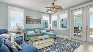 A living room with a blue sofa, a coffee table, and a patterned rug. - Just Beachy- Book 5+ nights & get 15% off Near Beach Club- 3BD/3BA. Sleeps 11 (Galveston)