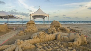 A beach with sand sculptures including a tent, a face, and a figure lying down. - Just Beachy- Book 5+ nights & get 15% off Near Beach Club- 3BD/3BA. Sleeps 11 (Galveston)