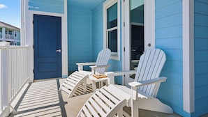 A porch with two white Adirondack chairs and a small table with a tray of food. - Just Beachy- Book 5+ nights & get 15% off Near Beach Club- 3BD/3BA. Sleeps 11 (Galveston)