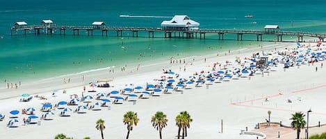 Una playa cerca, sillas reclinables de playa, sombrillas