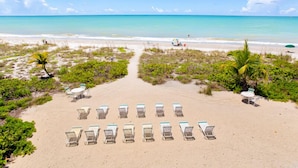 A beach with rows of sun loungers and a clear view of the ocean. - Direct Gulf Front ! Completely Renovated Modern 2 Bedroom ! (Sanibel)