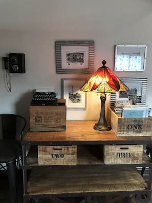 Un escritorio antiguo con una máquina de escribir, una lámpara y cajas de madera etiquetadas como 