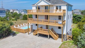 A multi-story building with a pool, wooden deck, and balconies. - Soundside Dog Friendly Home w/ Pool, Hot Tub, Game Room, Community Boat Ramp (Salvo)
