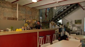 Un espace bar avec des tabourets, un comptoir et un escalier menant à un niveau supérieur.