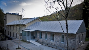 Un bâtiment moderne doté d’une façade en pierre et d’un toit métallique à pente.