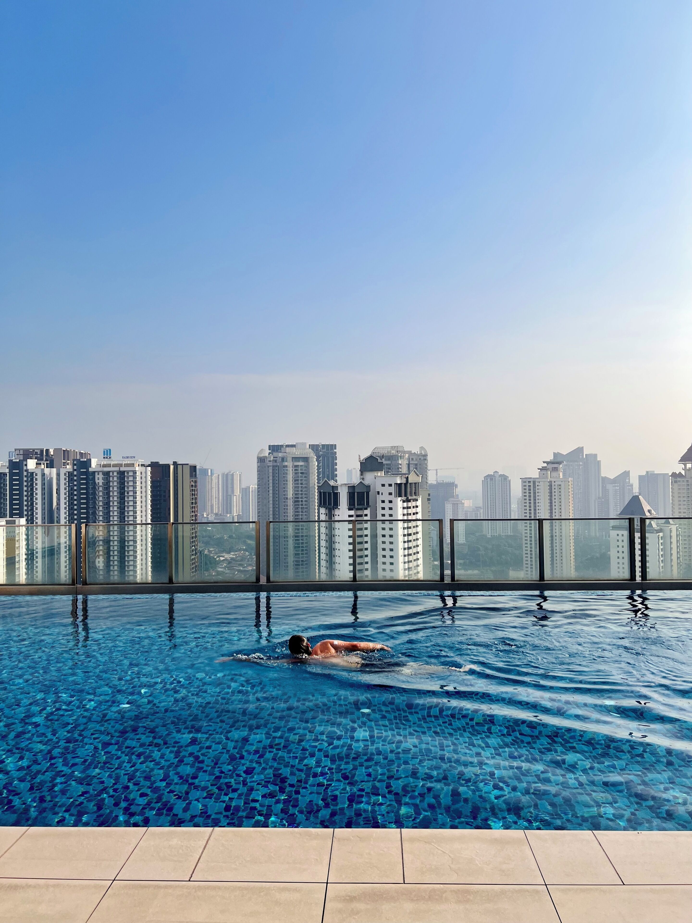A swimming pool with a cityscape view, surrounded by high-rise buildings.