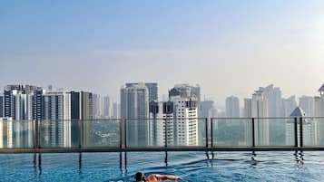 Piscina com vista para o horizonte urbano, rodeada por edifícios altos.
