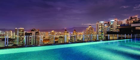 Una piscina al aire libre, sillones reclinables de piscina