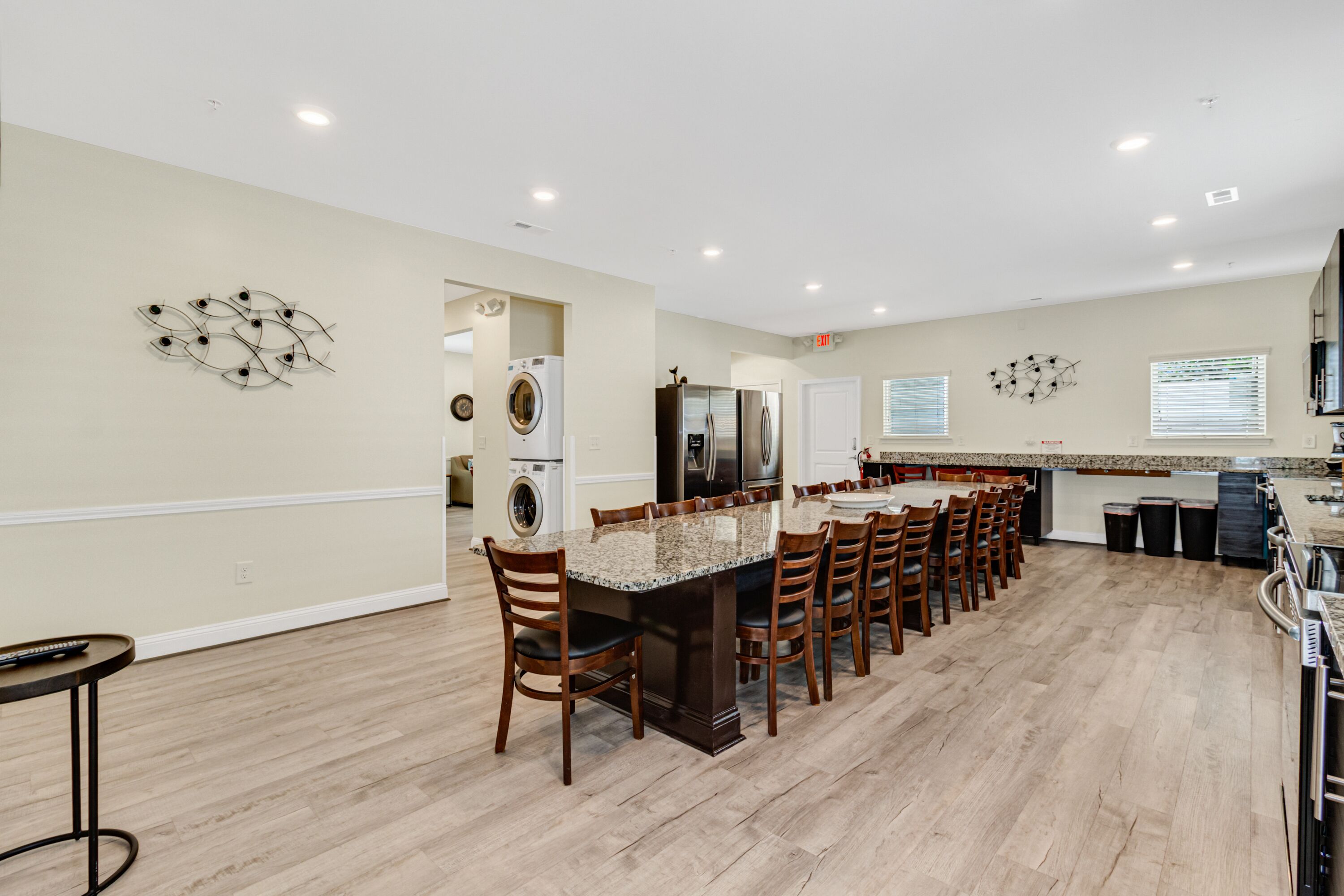A spacious kitchen with a central island, built-in appliances, and a dining area with chairs.