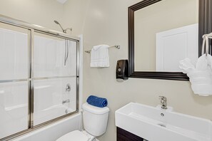 Kombinert dusj/badekar, håndklær og toalettpapir