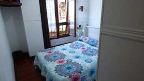 A bedroom with a bed, a window, and a door. - Pensión Santa María (Portugalete)