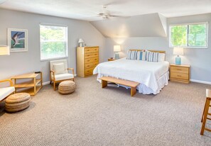 A bedroom with a large bed, a wooden dresser, a chair, a bench, and two bedside tables with lamps. - Two Free Kayaks included ! (Captiva)