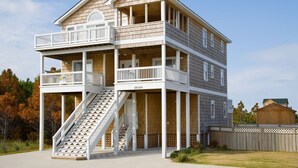 Une maison en bois à deux étages, dotée d’un balcon à l’étage supérieur, d’un escalier menant au deuxième étage et du numéro « 2618 » sur la façade.