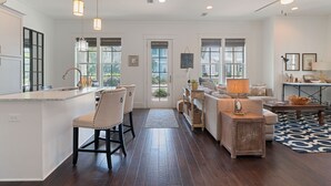 A spacious kitchen with a large island, bar stools, and pendant lighting. There is a living area with a sofa, coffee table, and a rug. - Spacious, golf cart included-pet friendly, short stroll to beach (Santa Rosa Beach)