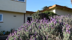 A two-story building with a beige exterior and a brown roof. - Birdies, Beaches and Butterflies in Pacific Grove! Pet Friendly-Premier location (Pacific Grove)