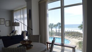 A room with a view of a pool and beach, a round table, wicker chairs, a sofa, and a lamp. - 3,000 Sq. Ft 2nd Floor 4 Bed/Bath End Unit  Ocean Side (Panama City Beach)