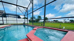 A swimming pool with red and white borders, surrounded by a metal fence.