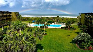 A resort with a pool, palm trees, and a view of the ocean. - CRC 3403 - Newly Renovated Direct Ocean View (St Augustine)