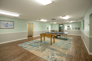 A spacious room with a foosball table, ping pong table, and a large rug. - CRC 3403 - Newly Renovated Direct Ocean View (St Augustine)