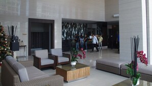 A spacious lobby with modern furniture, a Christmas tree, and decorative plants. - Modern Country Family Suite w/ Stunning Taal View (Tagaytay)