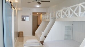 A modern bedroom with bunk beds, a ceiling fan, and a small side table. - Modern Country Family Suite w/ Stunning Taal View (Tagaytay)