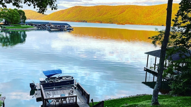 Une terrasse au bord du lac, avec des sièges d’extérieur, un quai et un belvédère.