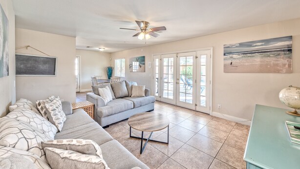 A spacious living room with a grey sectional sofa, a round coffee table, and a ceiling fan. - Lovely home -5 min from the strip (Las Vegas)