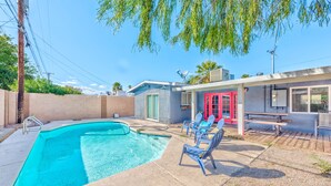 A swimming pool with lounge chairs and a red door. - Lovely home -5 min from the strip (Las Vegas)