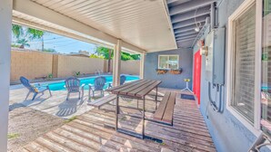 A covered patio with a pool, outdoor furniture, and a wooden deck. - Lovely home -5 min from the strip (Las Vegas)