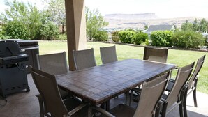 An outdoor patio with a tiled table and chairs, a grill, and a view of a hilly landscape. - PRIVATE POOL 34'x18', 25 Minutes to Zion,  Playset for Kids, 7 bdrm, sleeps 32 (Hurricane)