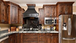 A kitchen with wooden cabinets, a stainless steel refrigerator, a microwave, and a stove. - PRIVATE POOL 34'x18', 25 Minutes to Zion,  Playset for Kids, 7 bdrm, sleeps 32 (Hurricane)