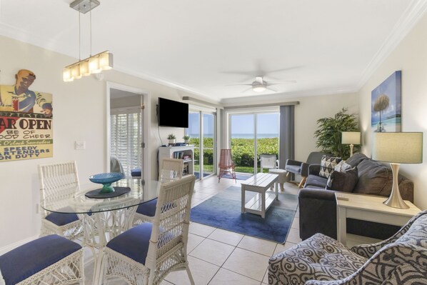 A spacious living area with a dining table, chairs, a sofa, and a TV.