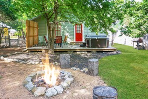 A rustic cabin with a fire pit, outdoor seating, and a barbecue grill. - Bungalows on the Square I Wimberley, hot tub (Wimberley)