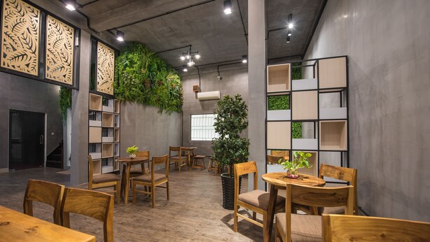 Un intérieur moderne avec des meubles en bois, des étagères intégrées et des plantes vertes.