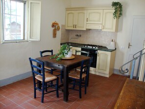 Enjoy meals in this cozy kitchen with a dining table for four, complete with a stove, oven, and ample natural light.
