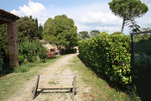 Stroll through the serene garden to a charming traditional building with a brick facade and sloped roof.
