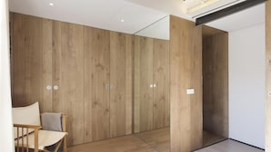 A modern room with wooden panel walls, a wooden floor, and a single chair.