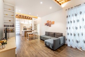 A modern living room with a sofa, a dining area, and a kitchen. - About Colosseo – Apartment at the Colosseum in the heart of Rome – Free Wi-Fi (Roma)
