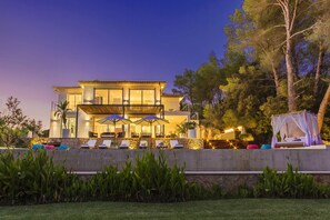 A modern two-story house with a balcony, outdoor seating area, and a well-maintained garden. - Villa Sol (Pollensa)