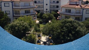 A large, multi-story building with a central tower, surrounded by lush greenery and a cobblestone pathway. - Obidos - Resort 5 * - Praia D'El Rey - Surf Golf & Beach - 2 bedroom apartment (Amoreira)