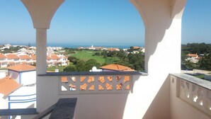 A balcony with a view of a coastal town, including houses and a golf course. - Obidos - Resort 5 * - Praia D'El Rey - Surf Golf & Beach - 2 bedroom apartment (Amoreira)
