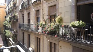 A multi-story building with balconies adorned with potted plants and flowers.