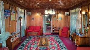 A traditional room with a patterned carpet, wooden furniture, and a unique ceiling design. - Shiraz Deluxe Houseboat (Srinagar)
